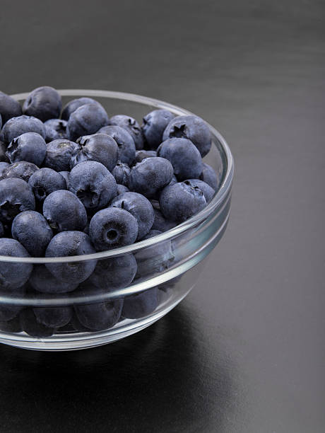 istock ripe blueberries in bowl isolated on black 501544524
