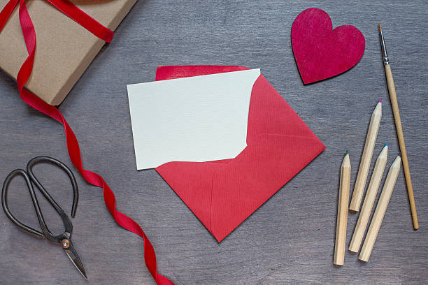 istock Red envelope with pencils and wooden heart 501545190