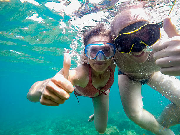 istock Couple joyfully swimming underwater in sea 501545878
