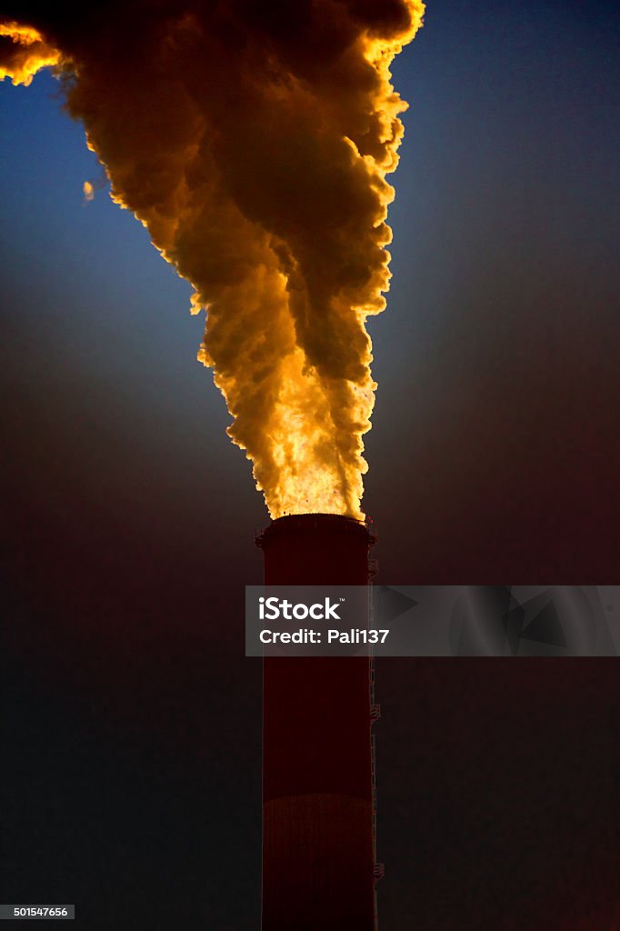 Factory pipe. Pollution. The smoke going from a factory pipe against the blue sky. 2015 Stock Photo