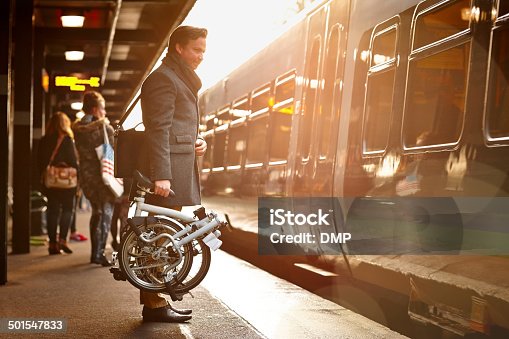 istock Businessman with folding cycle boarding train 501547833