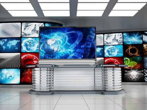 Television studio room with front desk, HD screen and video wall.