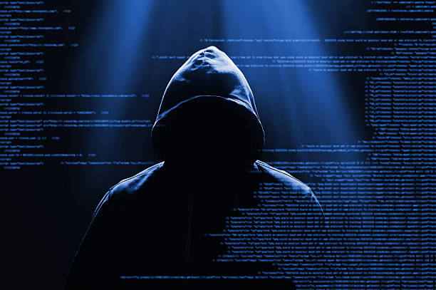 Computer hacker and computer software in the dark stock photo