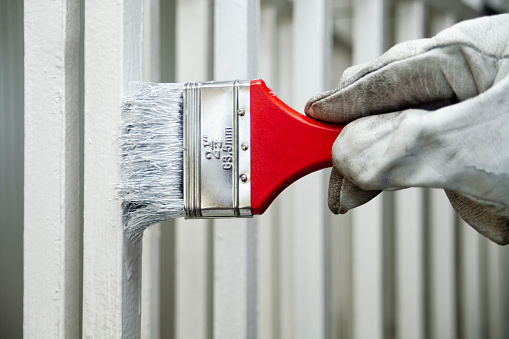 Painting the railing white with a paint brush