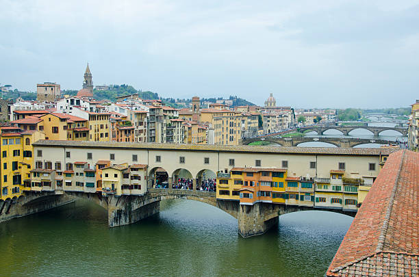Florence, Tuscany, Italy, 11 August 1992: the Ponte Vecchio with the famous Vasari Corridor, the artisans' shops and many tourists