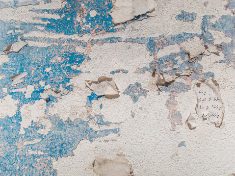 Peeling paint and paper on cement wall