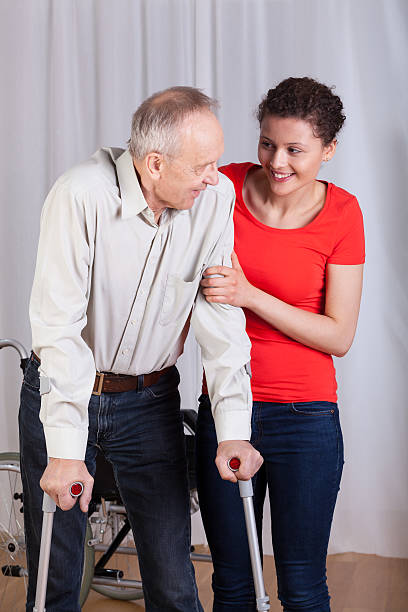 istock Woman helping a disabled to walk 501571677