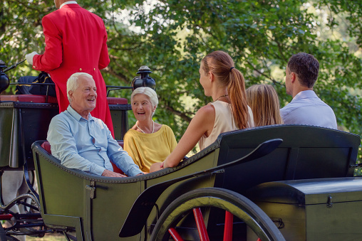 Three generation family carriage ride with coachman.
