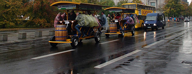Berlin, Germany - October 16, 2015: View Of Reichstag Building And Sightseeing Bus Including Many Tourists Having Fun Riding With Multi Passenger Human Powered Party Bike While It Is Raining In Berlin Germany,Europe.