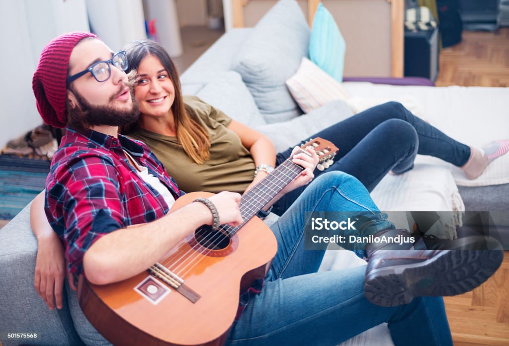 boyfriend playing to his girlfriend boyfriend playing to his girlfriend and singing,cheerful couple,indoor Affectionate Stock Photo