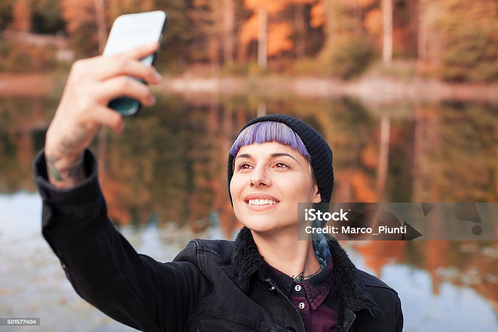 Hiker girl using smartphone at the mountain Girl taking "selfie" in the mountain, in front of the lake 2015 Stock Photo