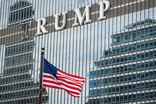 Chicago, USA - September 9, 2015: An American flag on the Michigan avenue bridge with famous Trump Tower on the Riverwalk in The Loop late in the day.
