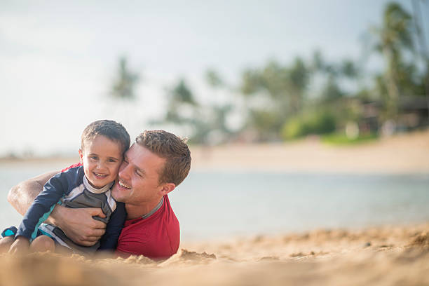 istock Father and Son Rolling in the Sand 501579990