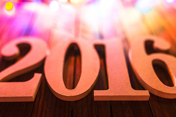 istock christmas light and 2016 New year text on plank wood 501580896