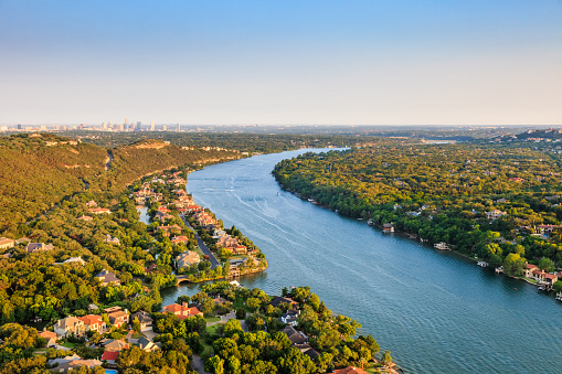 luxury homes on Colorado River near Austin TexasAerial view of Luxury homes on Colorado River in Mount Bonnell district in hill country near Austin Texas. City of Austin skyline in distance.