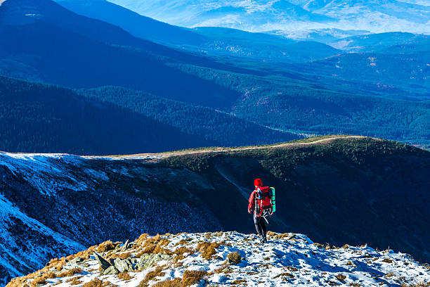 istock Hiker walking on Snow Slope Mountains stacked in far 501593590