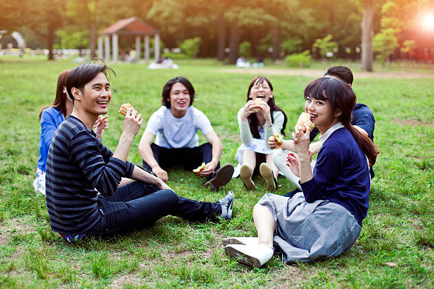 heureux groupe d'amis japonais repas dans le parc tokyo - coffee to go flash photos et images de collection