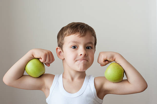 ragazzo con mele mostra bicipiti - childrens food foto e immagini stock