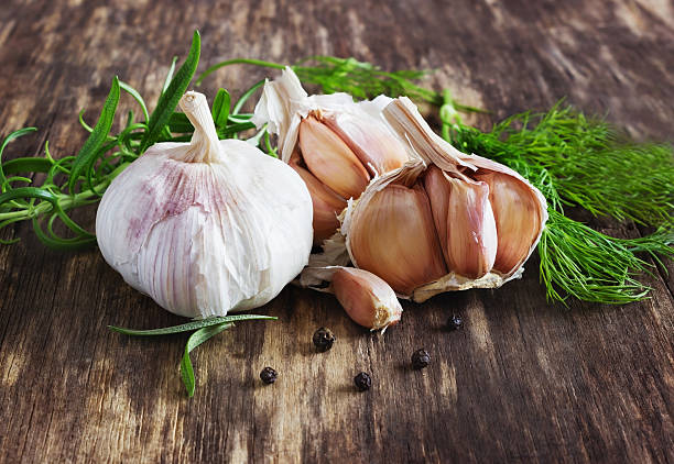 head of garlic and herbs head of garlic and herbs on a wooden table close-up. healthy food. rustic style. selective focus garlic clove photos stock pictures, royalty-free photos & images