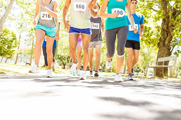 Low Section Of People Running Marathon At Park