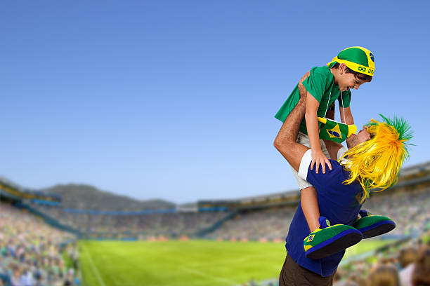 Brazilian fan at stadium with son celebrating a brazil team goal.
