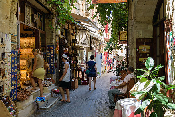 straße mit touristen und souvenir-geschäften in chania - lindos stock-fotos und bilder