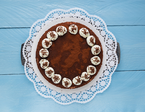 Tiramisu cake on blue rustic wood.