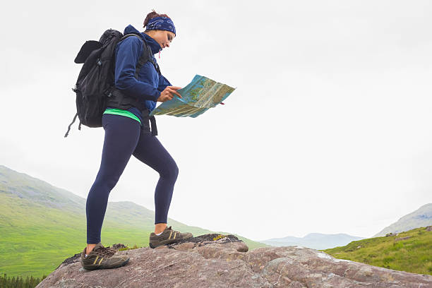 istock Woman standing on a rock reading map 501618259