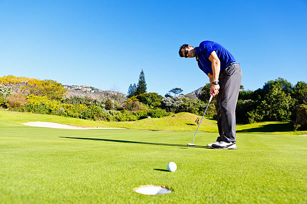 istock Young golfer putts, the ball heading towards the hole 501619079