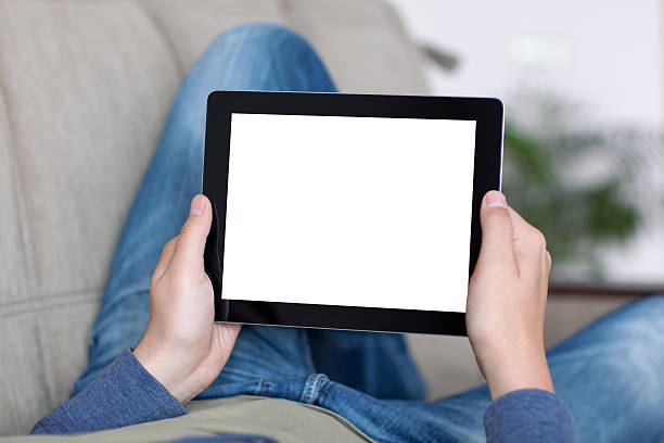 istock man lying on sofa and holding tablet with isolated screen 501619711