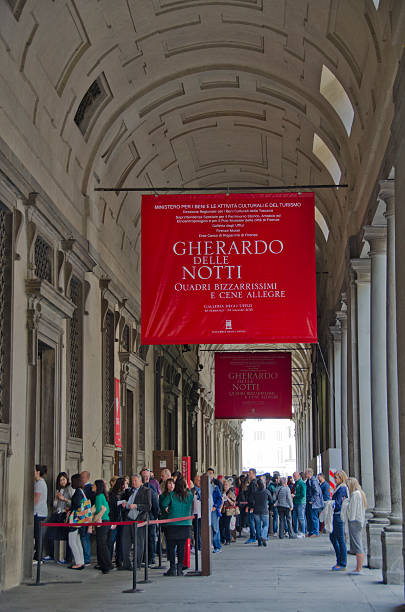 Lines of People at the Uffizi Gallery in Florence, Italy Florence, Italy - April 17, 2015: Florence, Italy is known as the birthplace of the Renaissance.  Founded in 80 B.C. by Lucius Cornelius Sulla as a settlement for his soldiers, it was named Fluentia, which later became Firenze.  Renown artists like Michelangelo, Leonardo da Vinci, Botticelli and Donatello all lived, studied and worked in Florence, along with architects like Brunelleschi, who designed the dome of the city's duomo, Cattedrale di Santa Maria del Fiore.  Florence has a colorful history as a political and financial center, dominated for over 150 years by the Medici family and is also known as a fashion center.  Today, it's rich heritage in art can be enjoyed at several galleries and museums including the Uffizi and the Gallerie dell'Accademia, as well as the Pitti Palace (Palazzo Pitti).  Pictured here are hundreds of people waiting in line to enter the Uffizi Gallery. michelangelo italy art david stock pictures, royalty-free photos & images