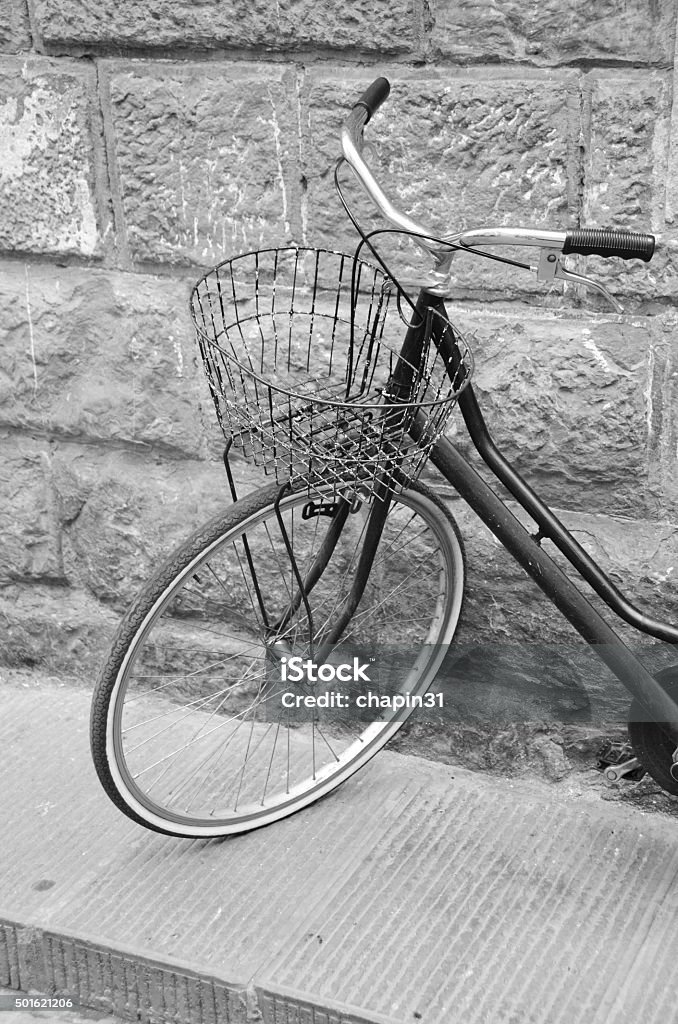 Old Bicycle in Florence, Italy Florence, Italy is known as the birthplace of the Renaissance.  Founded in 80 B.C. by Lucius Cornelius Sulla as a settlement for his soldiers, it was named Fluentia, which later became Firenze.  Renown artists like Michelangelo, Leonardo da Vinci, Botticelli and Donatello all lived, studied and worked in Florence, along with architects like Brunelleschi, who designed the dome of the city's duomo, Cattedrale di Santa Maria del Fiore.  Florence has a colorful history as a political and financial center, dominated for over 150 years by the Medici family and is also known as a fashion center.  Today, it's rich heritage in art can be enjoyed at several galleries and museums including the Uffizi and the Gallerie dell'Accademia, as well as the Pitti Palace (Palazzo Pitti).  Pictured here is an old bicycle with a wire basket in downtown Florence. 2015 Stock Photo