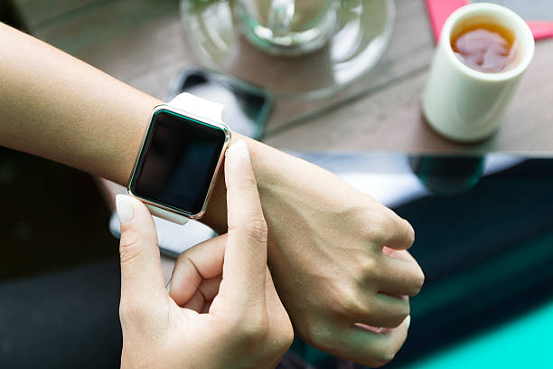 Hand using Apple Watch in coffee shop stock photo