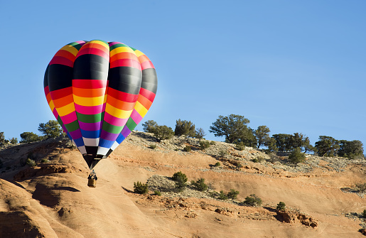 A hot air balloon lands on a meadow near Goreme in Cappadocia