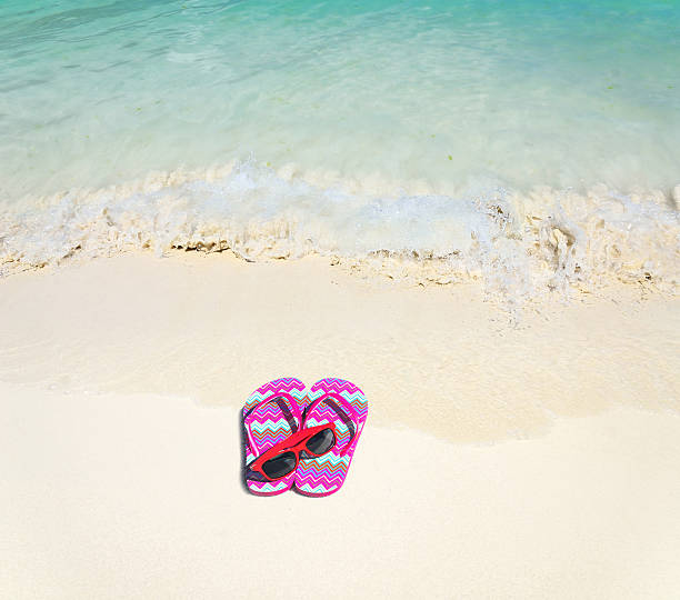 istock Red Flip-flops and sunglasses at the sandy beach 501626246