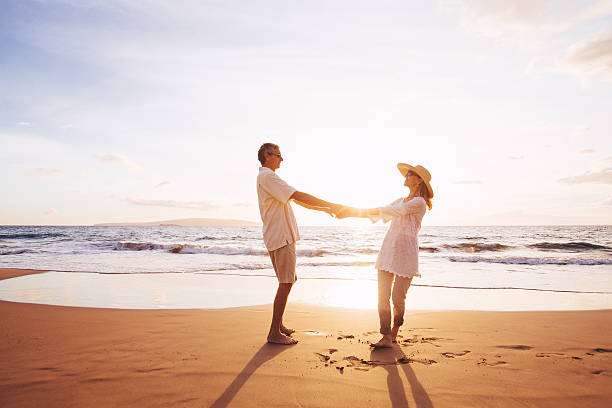 istock Mature Couple Walking on the Beach at Sunset 501631988