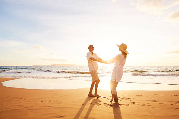 istock Mature Couple Walking on the Beach at Sunset 501632034
