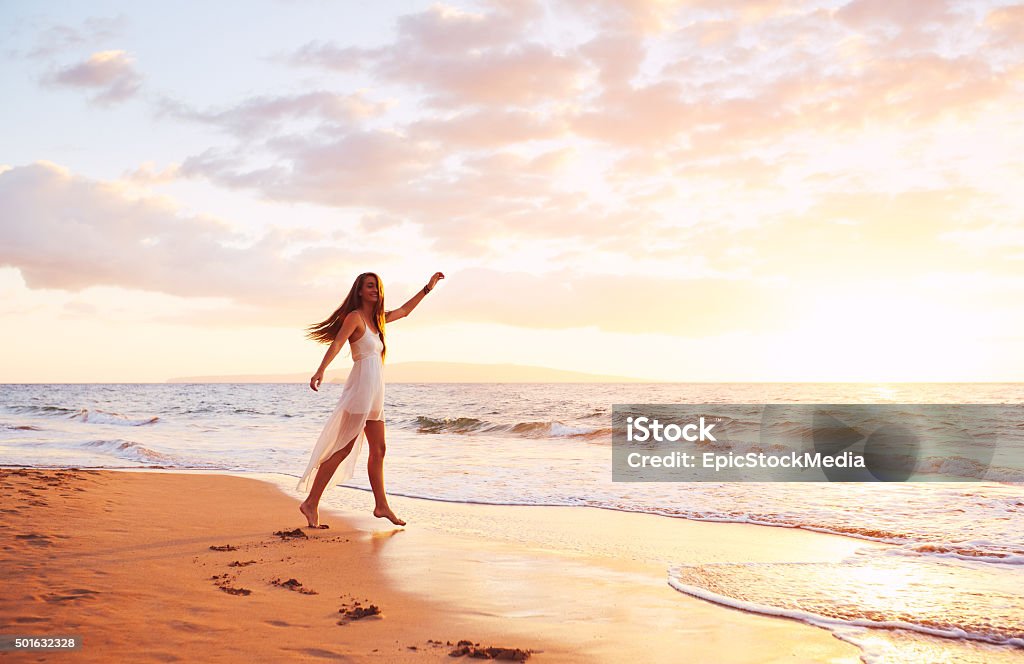 Happy Carefree Woman Dancing on the Beach at Sunset Happy carefree woman dancing at sunset on the beach. Happy free lifestyle concept. 2015 Stock Photo