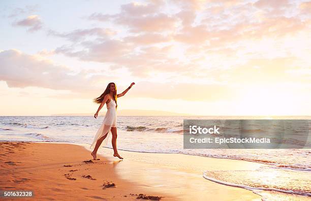 Happy Carefree Woman Dancing On The Beach At Sunset Stock Photo - Download Image Now