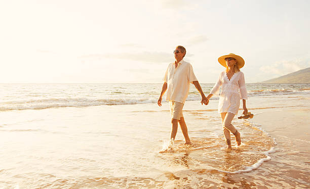 istock Mature Couple Walking on the Beach at Sunset 501632350