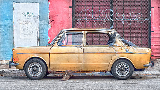 istock Abondoned Car In Ghetto Street With Graffiti Wall 501644691