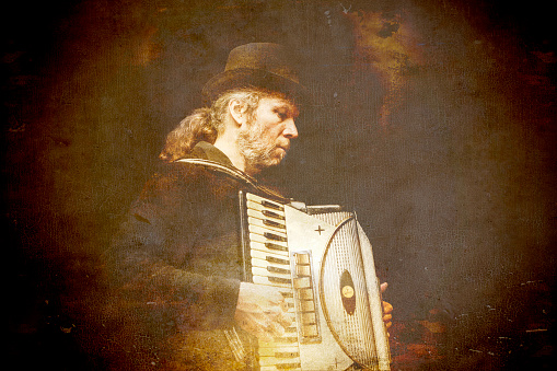 Gypsy accordion player processed with textures for a vintage grunge look.