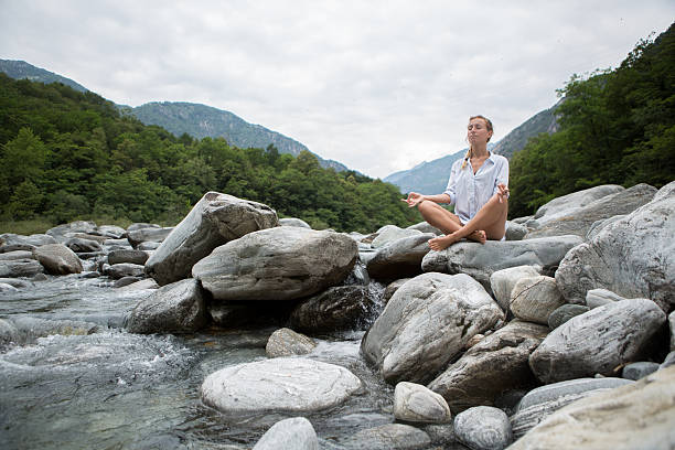 istock Young woman practicing yoga by the river 501644951