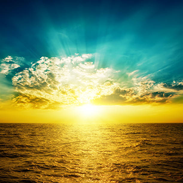 istock orange sunset in dark blue sky over yellow sea 501646392