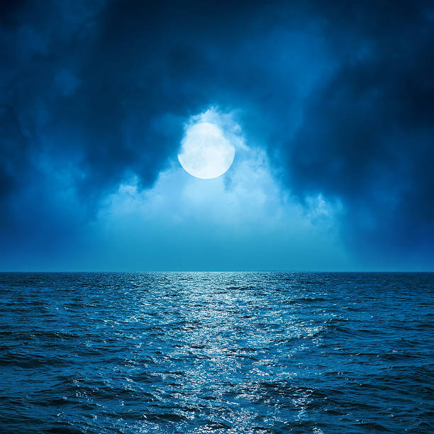 istock full moon in clouds over dark blue sea 501646446