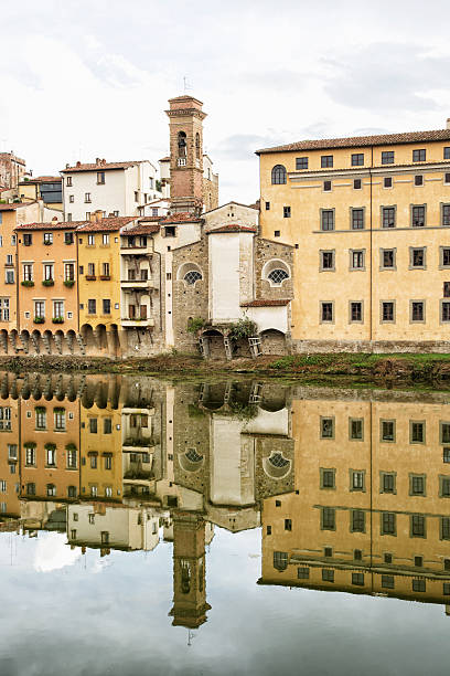 istock Historical buildings with bell tower mirrored in the river Arno, 501646558