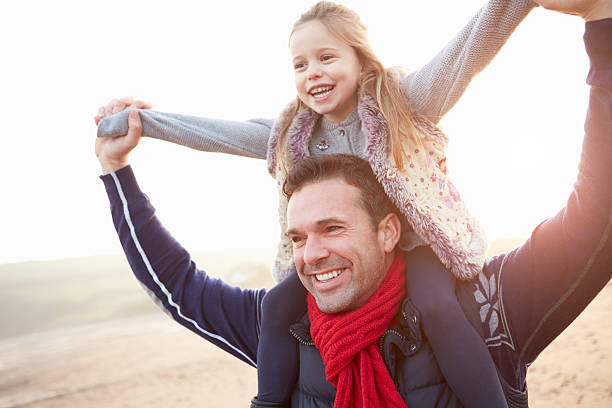 istock Father And Daughter Walking On Winter Beach 501647215