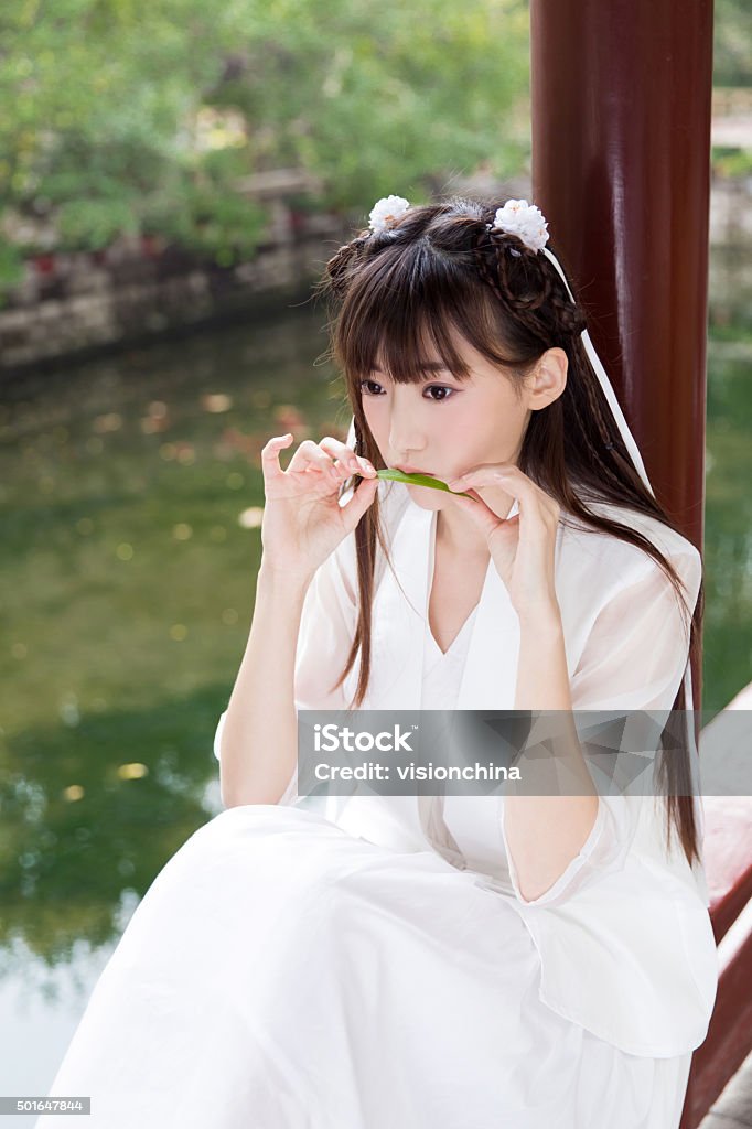 pretty young chinese girl in a beautiful park, a young girl holding a fan, in the bridge, at the fountain 20-29 Years Stock Photo