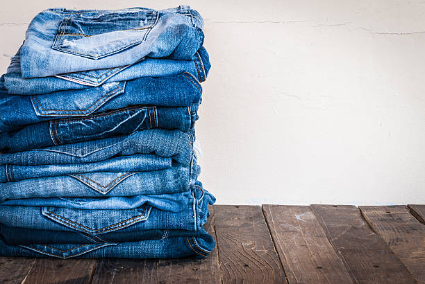 stack of various shades of blue jeans on old wood stack of various shades of blue jeans on old wood stack rock stock pictures, royalty-free photos & images