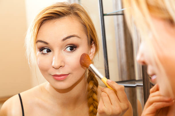 istock Beautiful woman doing makeup on her face 501648735